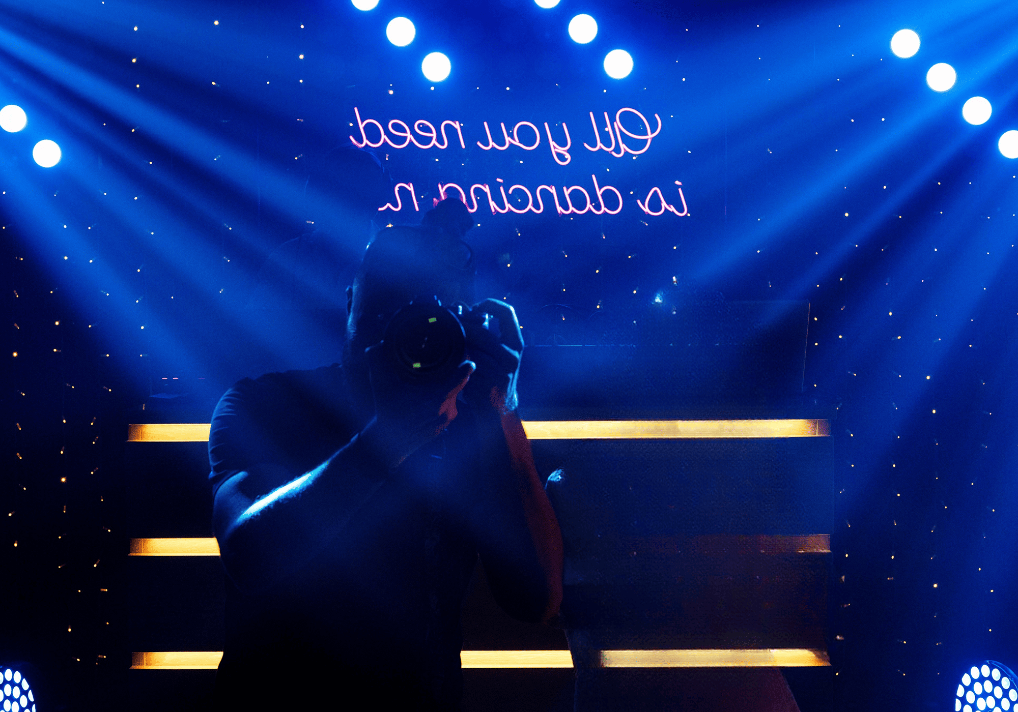 Fotógrafo con cámara en un ambiente iluminado.